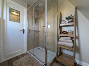 a shower with a glass door in a bathroom at The Chalet, Kildonan in Edinbain