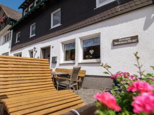a wooden bench sitting in front of a house at Dreibettzimmer mit Dusche und Wc in Lennestadt