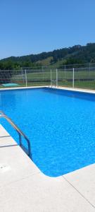 a large blue swimming pool with a fence at Rincón de Candelaria in Solórzano