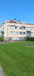 a building with a grass field in front of it at Rincón de Candelaria in Solórzano