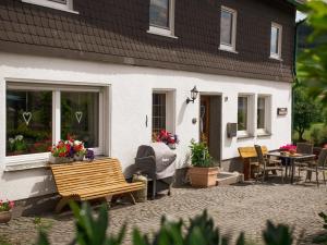 a white house with a patio and a table and chairs at Doppelzimmer mit Dusche und Wc in Lennestadt