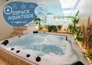 a jacuzzi tub in a room with plants at Appart'Hôtel & Spa "Les Voiles" Le Brehat in Carnac