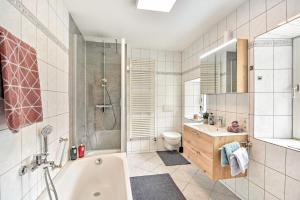 a bathroom with a tub and a toilet and a sink at Kleines Stadthaus mit Sauna in Hillesheim +13 photos