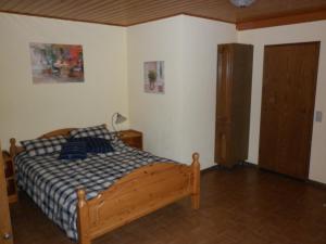 a bedroom with a wooden bed and a wooden door at Ferienwohnung Schwalbennest in Lennestadt