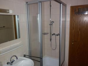 a bathroom with a shower with a sink and a tub at Ferienwohnung Schwalbennest in Lennestadt +10 photos