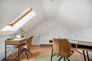 a room with a desk and chairs in a attic at Kleines Stadthaus mit Sauna in Hillesheim