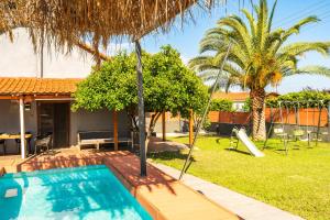 a backyard with a swimming pool and palm trees at Holiday Home Potidaia in Nea Potidaea