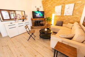 a living room with a couch and a tv at Holiday Home Potidaia in Nea Potidaea