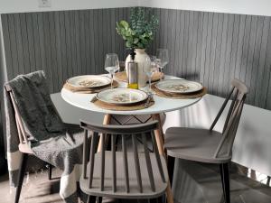 a white table with plates and glasses on it at Argiros Apartments in Kefalos
