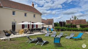 a yard with chairs and tables and a building at Le Tarare in Guipy