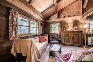 a living room with a bed and chairs in a cabin at Chalet Familial Chaleureux in Abondance