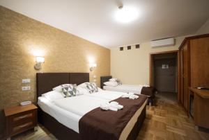 ein Hotelzimmer mit zwei Betten, auf denen Handtücher liegen in der Unterkunft Dóm Hotel in Szeged + 45 Fotos