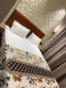 a bed with a wooden headboard and white sheets at Stay Karo Yaar in Ghaziabad