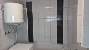 a bathroom with a shower with black and white tiles at Villa Sunset in Podastrana +22 photos