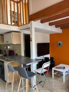 a kitchen with a table and chairs in a room at Janislove34 Maison 1 Chambre avec accès piscine dans résidence à Palavas les flots in Palavas-les-Flots