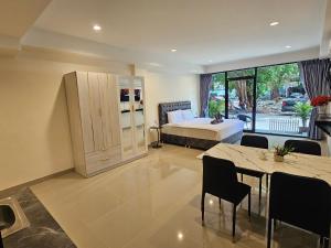 a bedroom with a bed and a table and chairs at Candy Beach Seaview Jomtien in Jomtien Beach