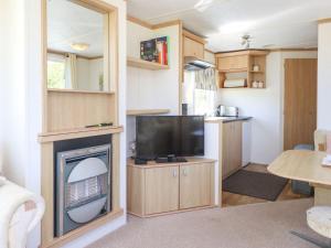a living room with a flat screen tv and a living room at The Lodge Caravan Rental in Amlwch