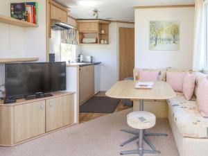 a living room with a couch and a table at The Lodge Caravan Rental in Amlwch
