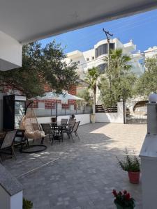 a patio with chairs and tables and a building at Vila Ani in Ksamil