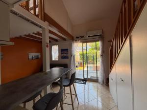 a kitchen with a counter and chairs in a room at Janislove34 Maison 1 Chambre avec accès piscine dans résidence à Palavas les flots in Palavas-les-Flots