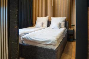 two beds with white sheets and pillows in a room at Kaszmir Apartments in Opole