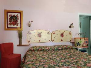 a bedroom with a bed and a red chair at Appartamento Zero Pensieri in San Benedetto del Tronto