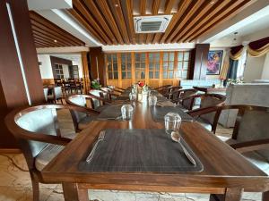 a dining room with a long wooden table and chairs at Hotel Tapowan - Near Tribhuvan International Airport in Kathmandu