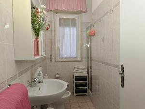 a bathroom with a sink and a toilet and a window at Appartamento Zero Pensieri in San Benedetto del Tronto