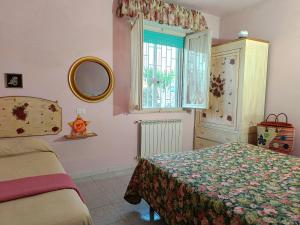 a bedroom with a bed and a window and a mirror at Appartamento Zero Pensieri in San Benedetto del Tronto