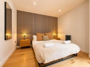 a bedroom with a large bed with two night stands at West Townhouse by CasaCity in Manchester