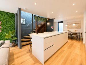 a kitchen with a white counter and a dining room at West Townhouse by CasaCity in Manchester