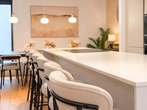 a bar with a row of chairs in a room at West Townhouse by CasaCity in Manchester