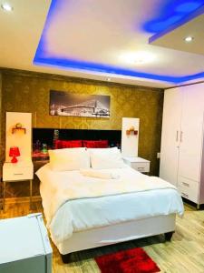 Ein Schlafzimmer mit einem großen weißen Bett und blauer Decke in der Unterkunft A & A Hotel in Lungi
