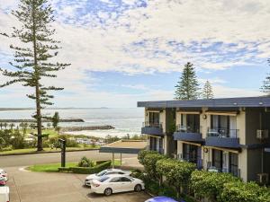 a building with cars parked in a parking lot at ibis Styles Port Macquarie in Port Macquarie