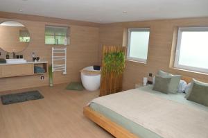 a bedroom with a bed and a bathroom with a tub at Horizon d'or in Profondeville