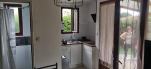 a woman standing in a kitchen with a window at Maison à la mer in Vendres