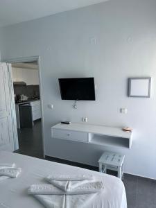 Ein weißes Schlafzimmer mit einem Fernseher an einer weißen Wand in der Unterkunft Niriides Hotel Apts Studios in Almyrida