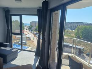 a room with a balcony with a view of a parking lot at Beach apartments Ema in Kranevo +50 photos