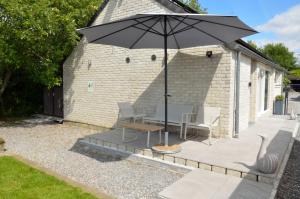 a patio with two chairs and an umbrella at Horizon d'or in Profondeville +19 photos