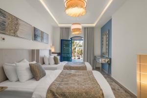a hotel room with two beds and a balcony at Santorini check in in Ras al Khaimah