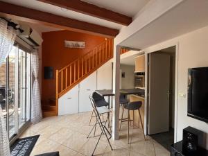 a living room with a table and chairs and a staircase at Janislove34 Maison 1 Chambre avec accès piscine dans résidence à Palavas les flots in Palavas-les-Flots