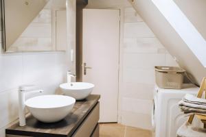 a bathroom with two white sinks on a counter at Le nid du Randonneur in Marmanhac +23 photos