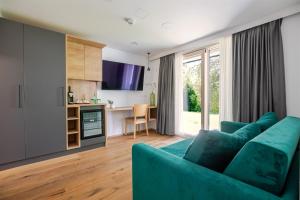 ein Wohnzimmer mit einer blauen Couch und eine Küche in der Unterkunft Hotel Ottenstein - Das Wohlfühlhotel in Rastenfeld