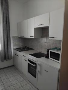 a kitchen with white cabinets and a stove top oven at Ferienwohnung DuO in Stubenberg +5 photos