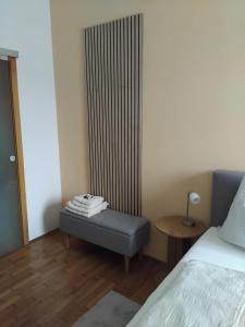 a room with a bed and a bench next to a radiator at Ferienwohnung DuO in Stubenberg