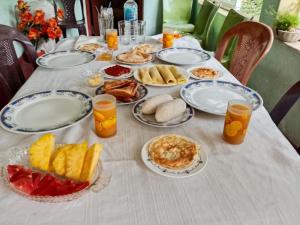 a table with plates of breakfast food on it at Coco Breeze Cabanas by Dr Aruna - Free Airport drop off or pick up 24H, free secure Luggage Holding in Katunayaka +26 photos