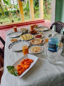 a table topped with plates of food on a table at Coco Breeze Cabanas by Dr Aruna - Free Airport drop off or pick up 24H, free secure Luggage Holding in Katunayaka