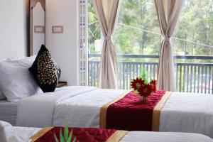 a bedroom with two beds and a window at Altiora Homestay in Kodaikānāl