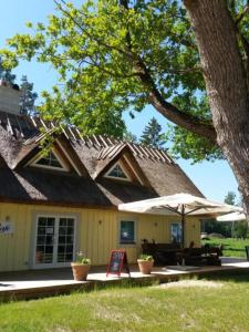 a house with an umbrella and a sign in front of it at Luigeranna B&B in Küdema