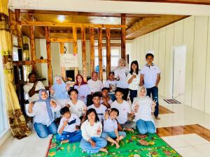 a group of people posing for a picture in a room at Yus homestay in Bukittinggi